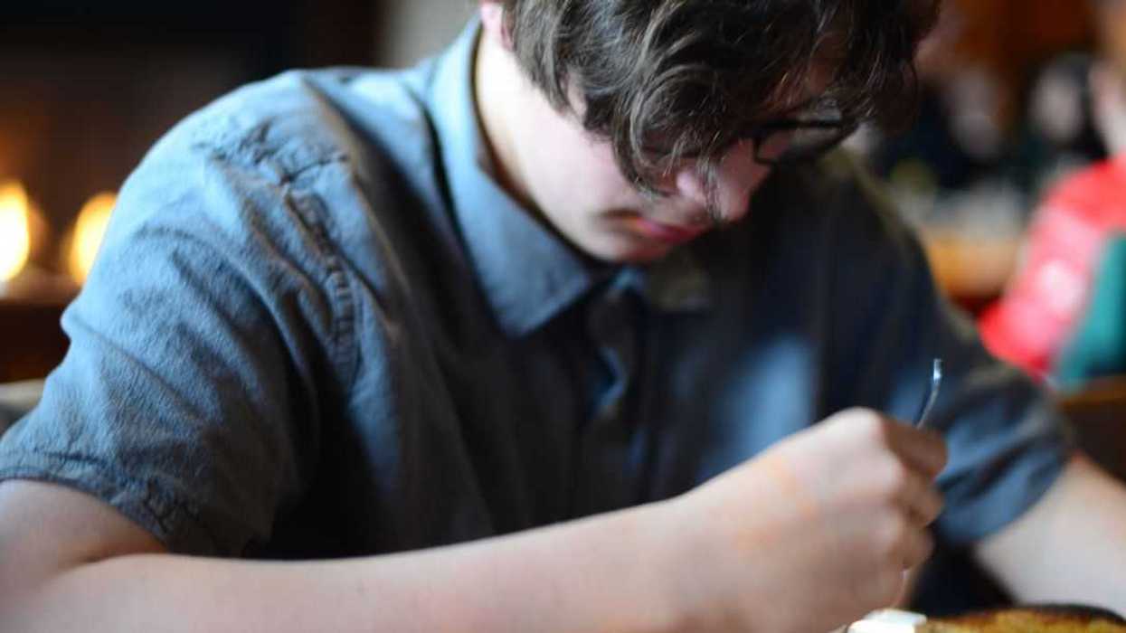 15-Year Old Boy Eating Pasta in a Restaurant.