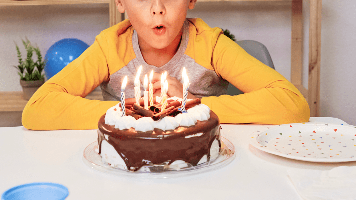 A Boy blowing out birthday candles.