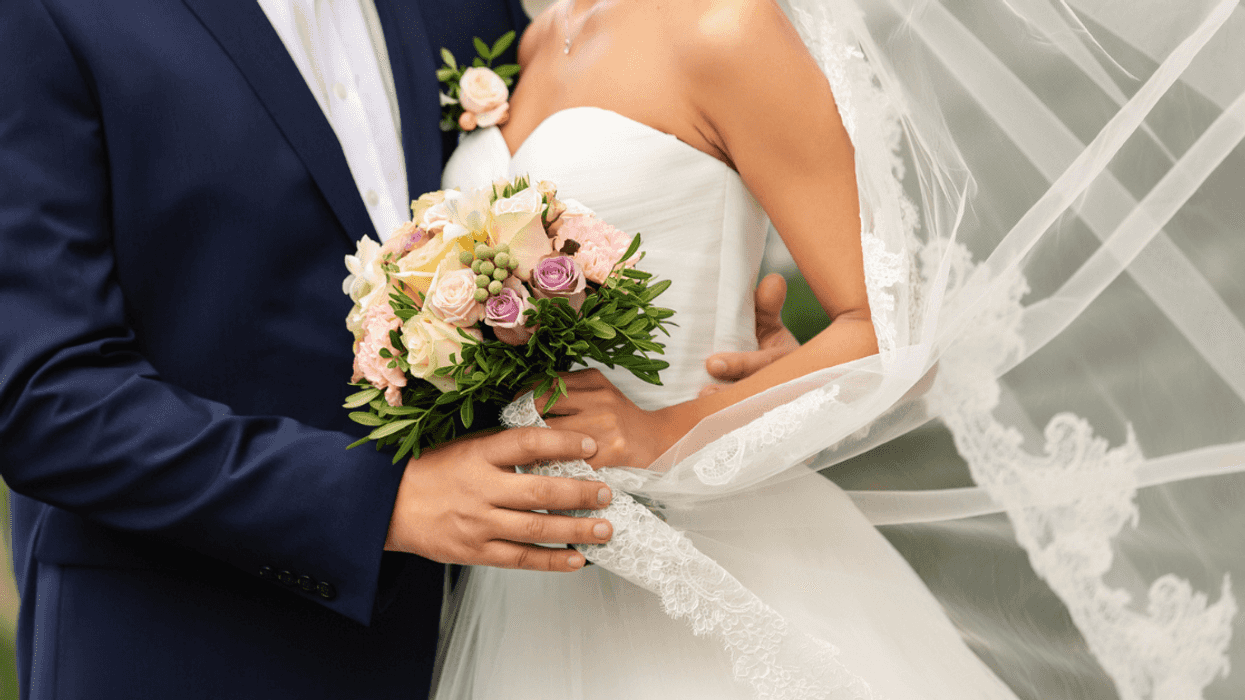 A bride and a groom embracing.