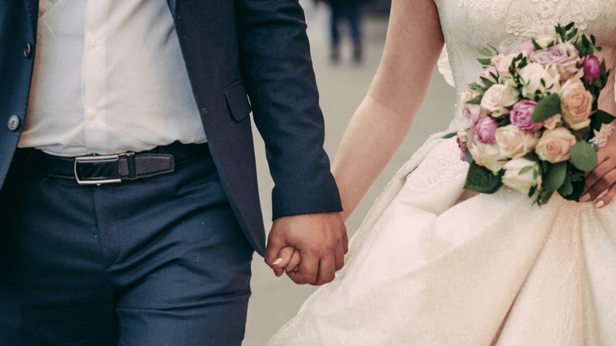 A bride and a groom holding hands.