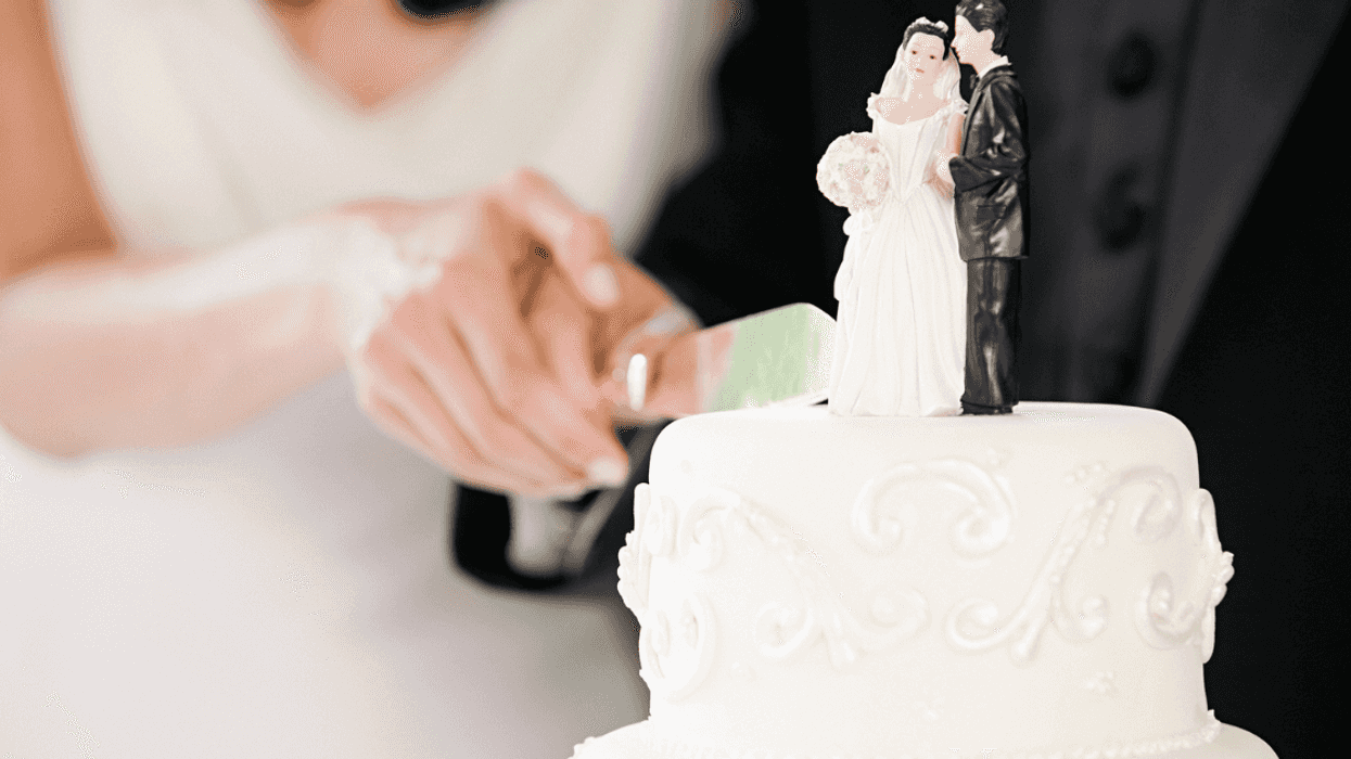 A bride and groom cutting a wedding cake.
