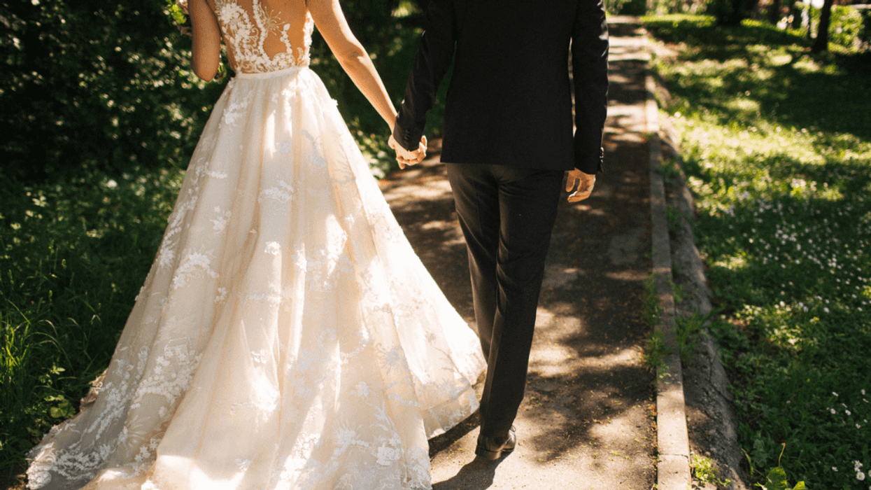 A bride and groom walking hand in hand.