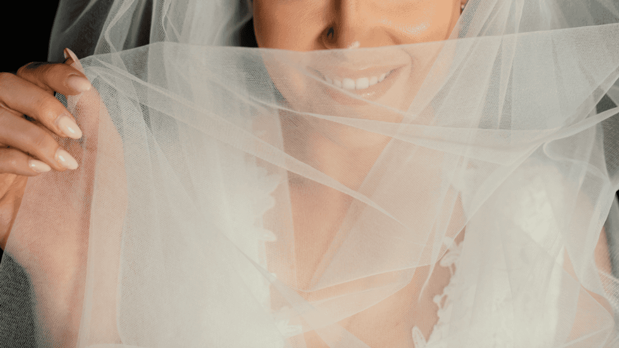 A bride covering her face with a veil.