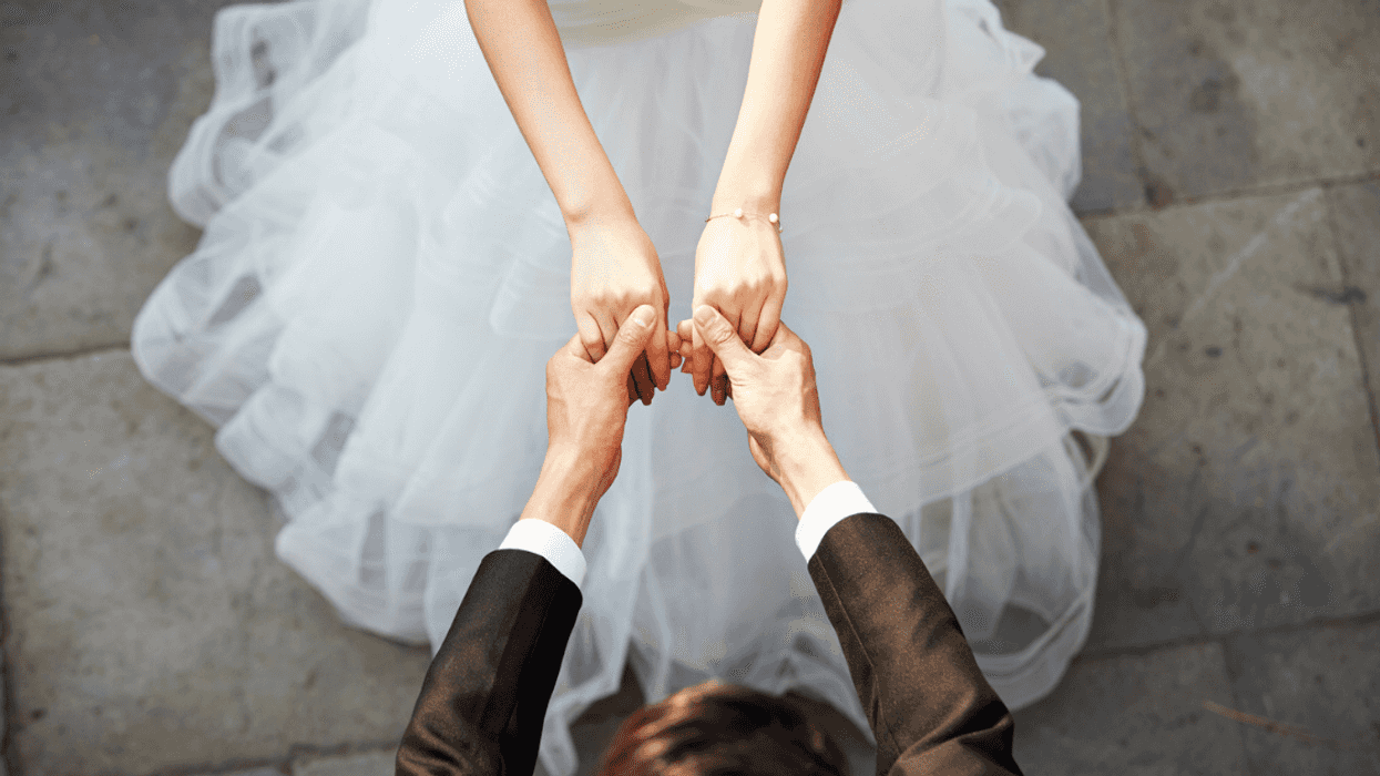 a bride holds hands with a man in a tuxedo