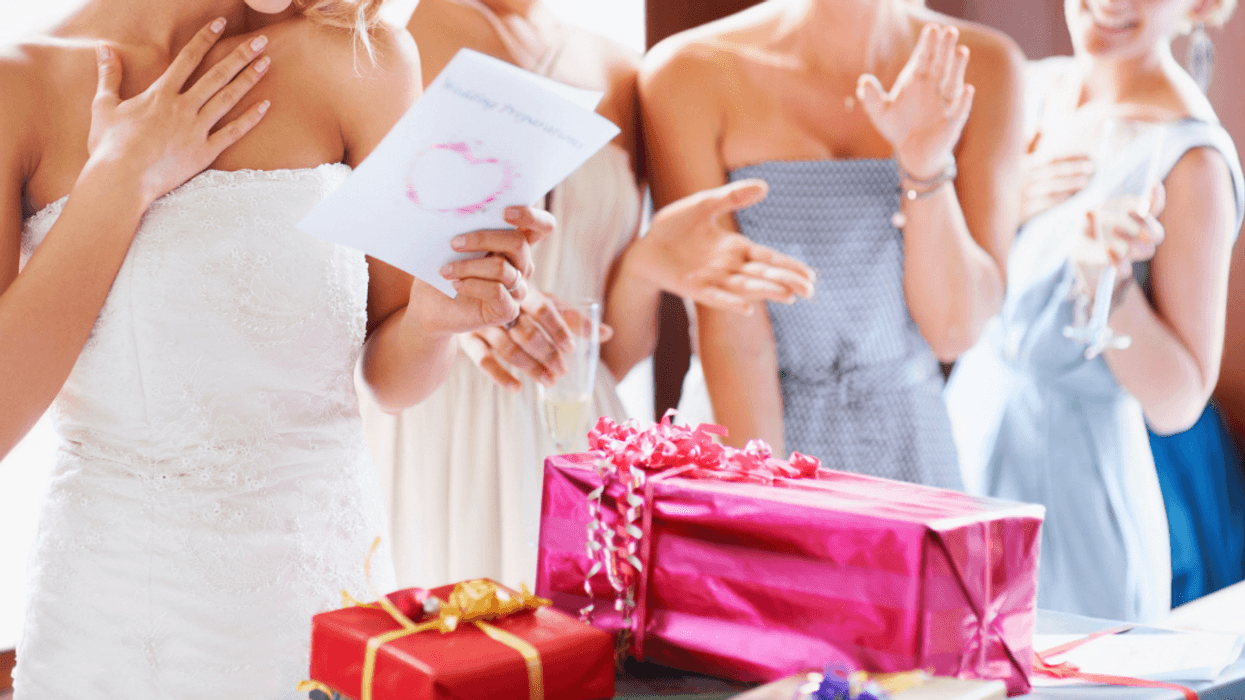 A bride looking at presents with a bridesmaids looking on.