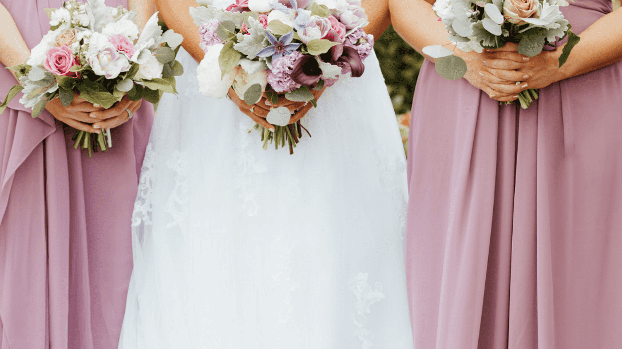 A bride surrounded by two bridesmaids.