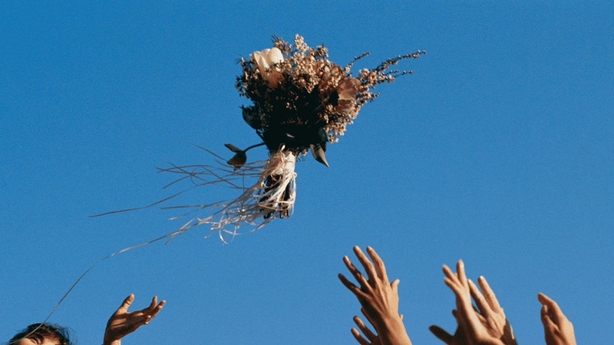 a bride throwing a bouquet at wedding.