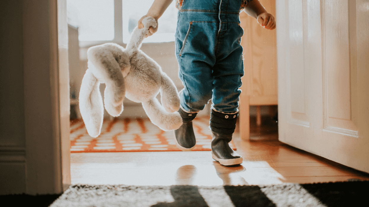 A child holding a stuffed bunny in their hand.