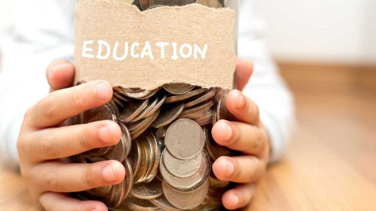 A child's hands holds a jar of coins that is labeled... "Education."
