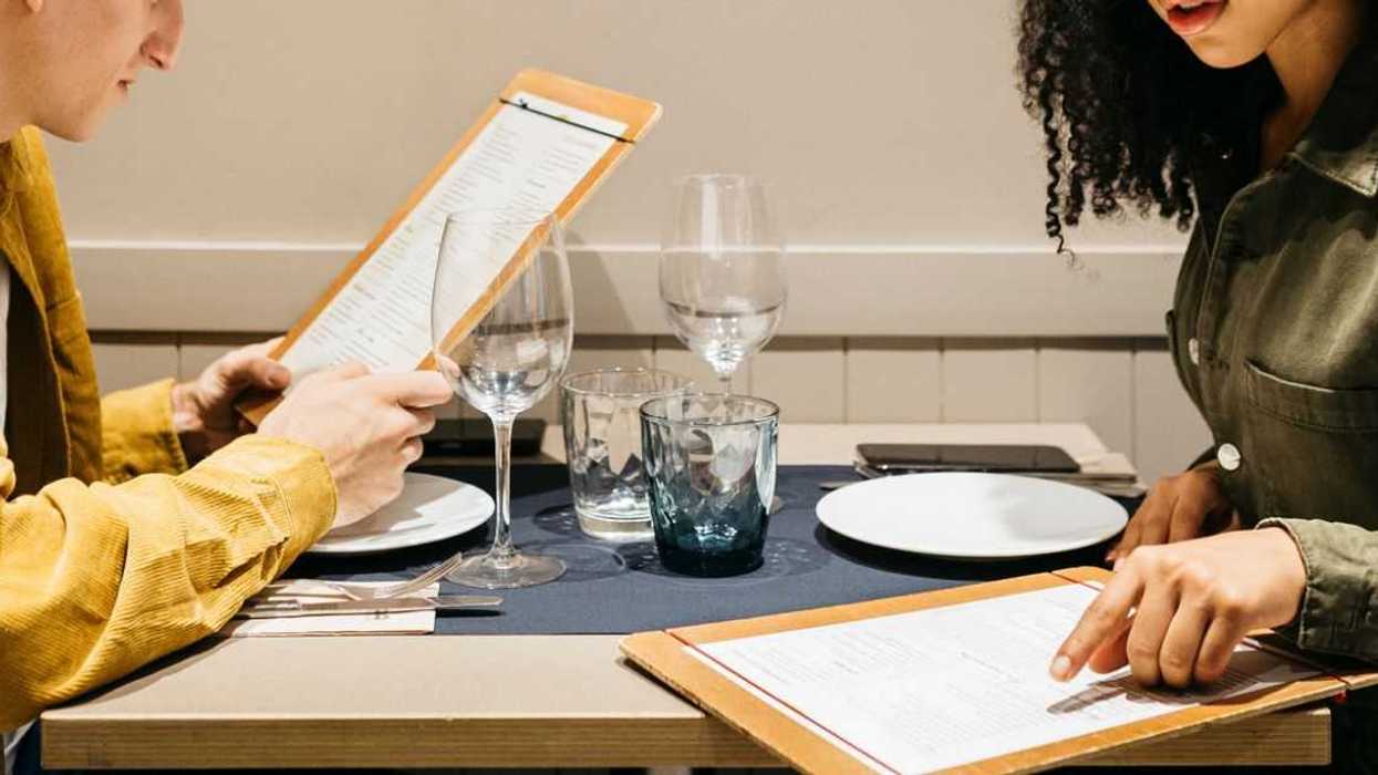 A couple at dinner looks at the menu