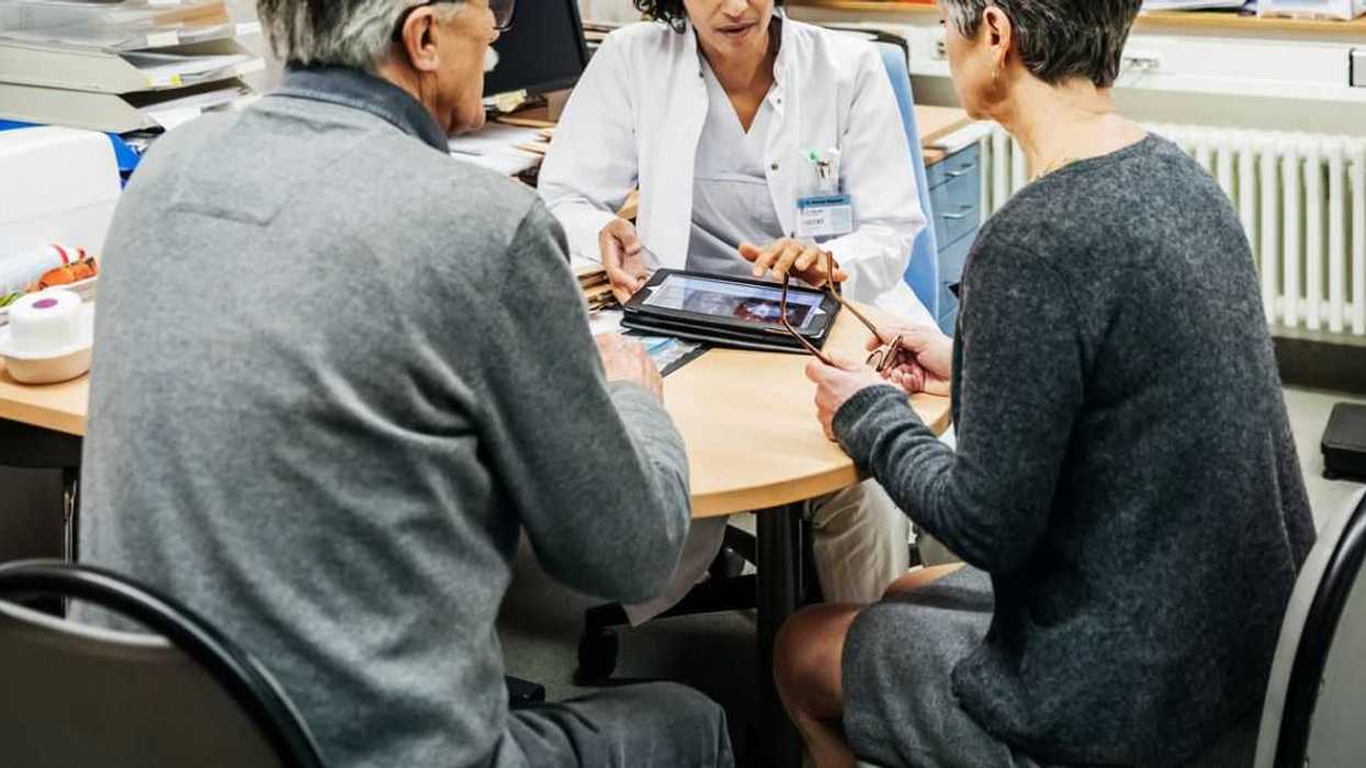 A couple sits talking to the doctor