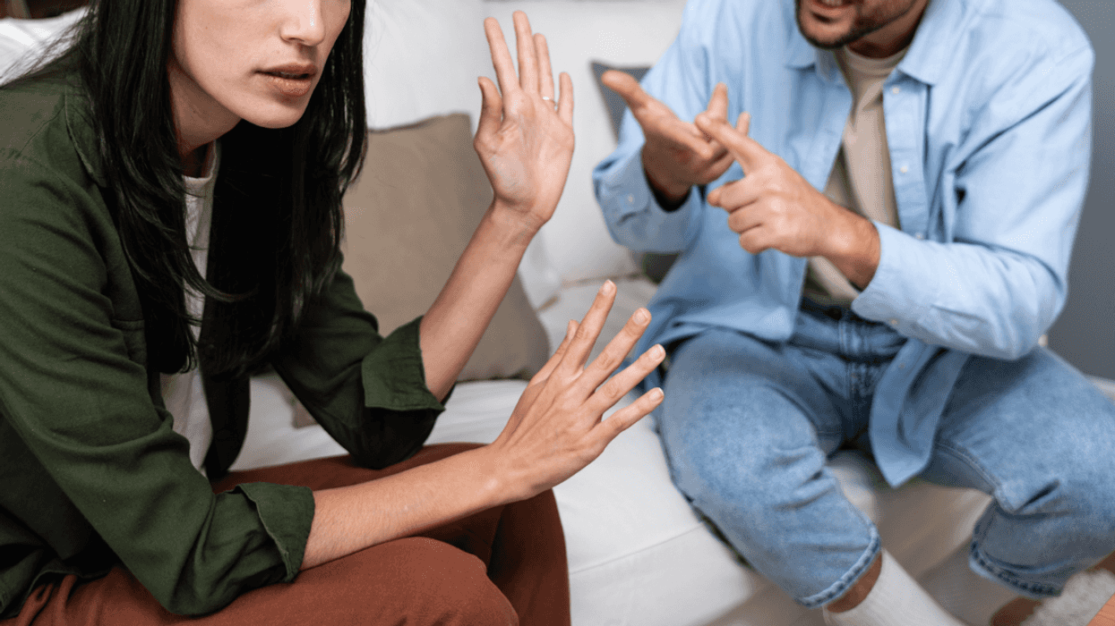 A couple sitting on the sofa having an argument.