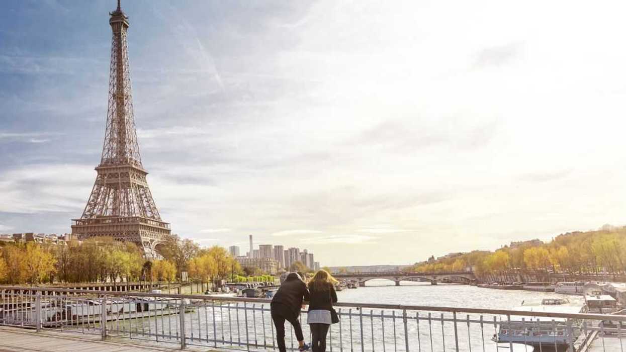 A couple standing in front of the Eiffel tower.