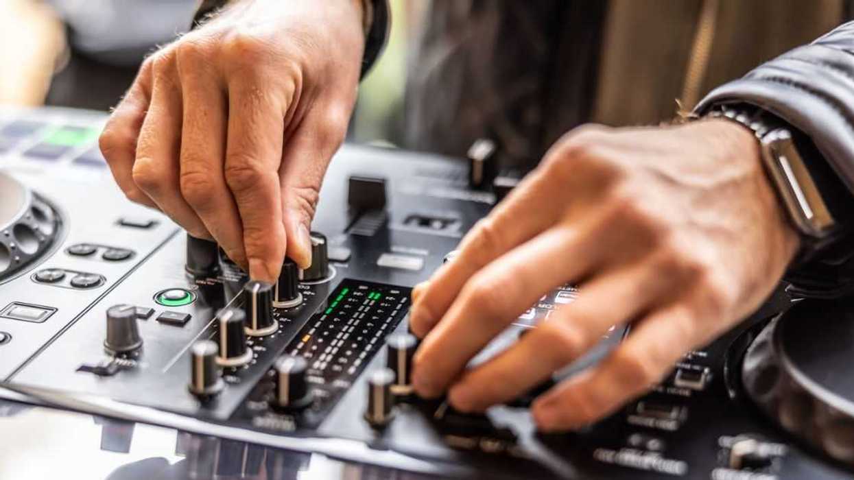 A DJ's hands mix the tables