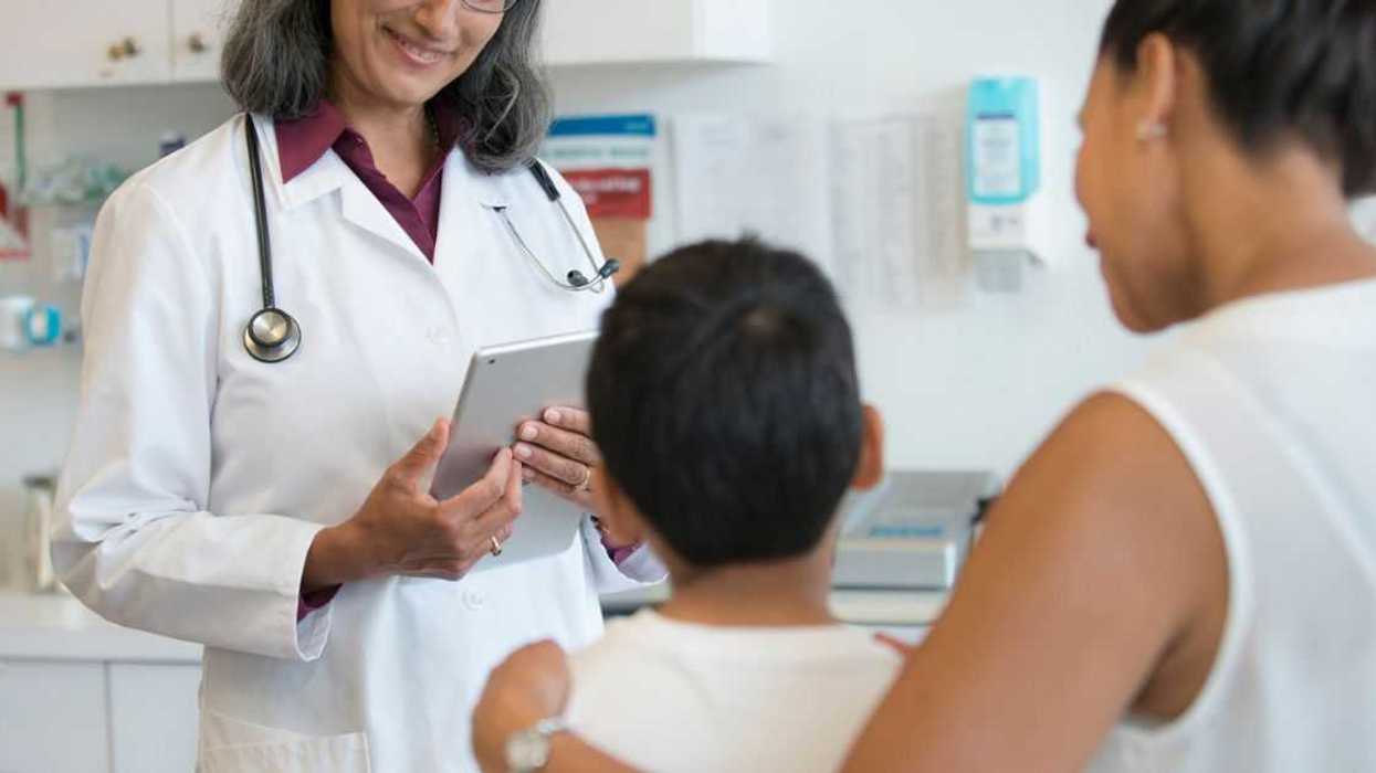 A doctor talks with a young boy and his mom
