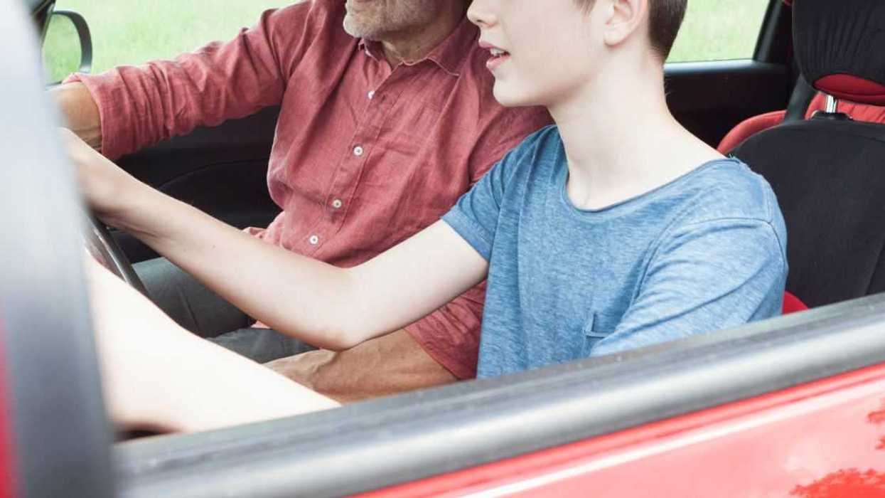 A father teaches his son to drive