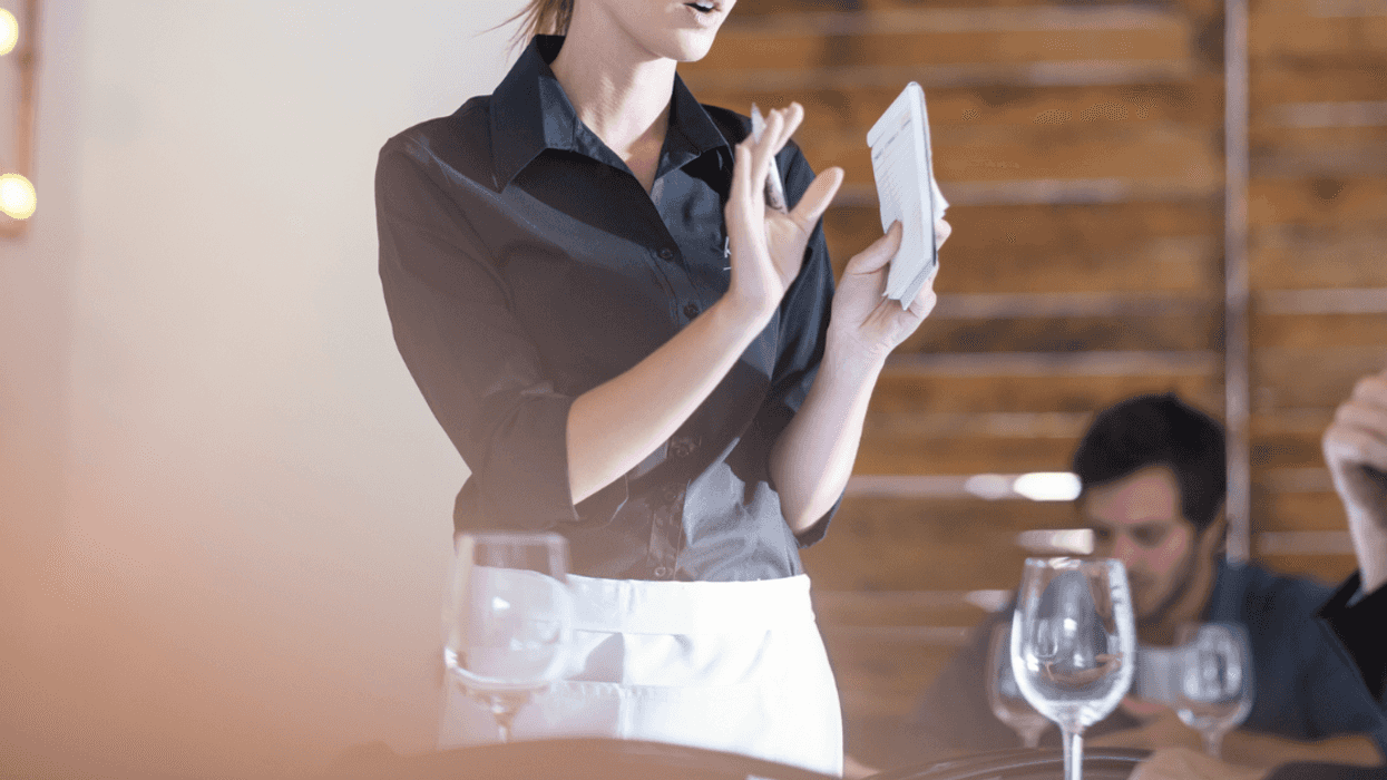 A female server holding her hand up.