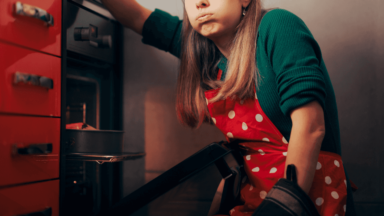 A frustrated woman in front of an oven.