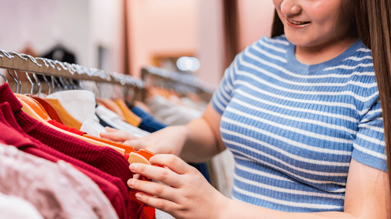 A girl looking at clothes on a clothing rack