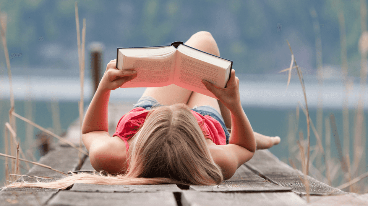 A girl reading on a dock