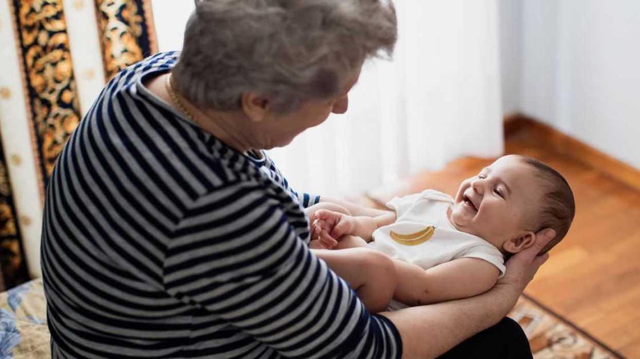 A grandmother lovingly holds a baby