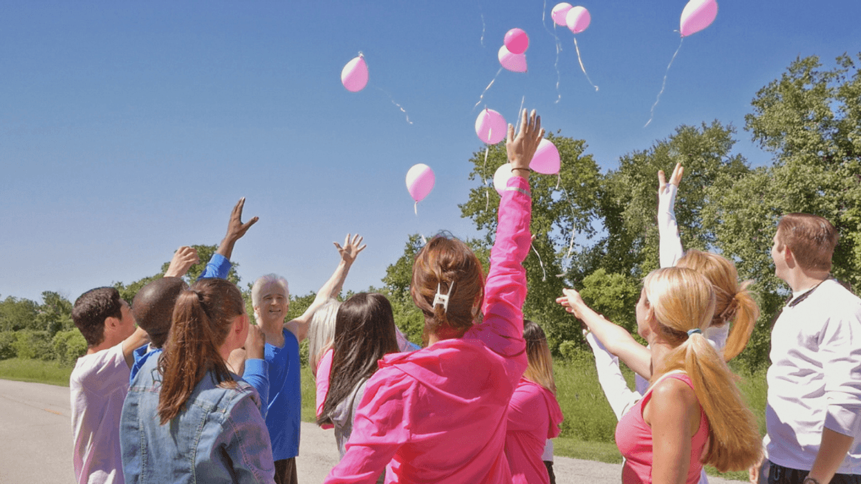 A group of people releasing balloons into the air.