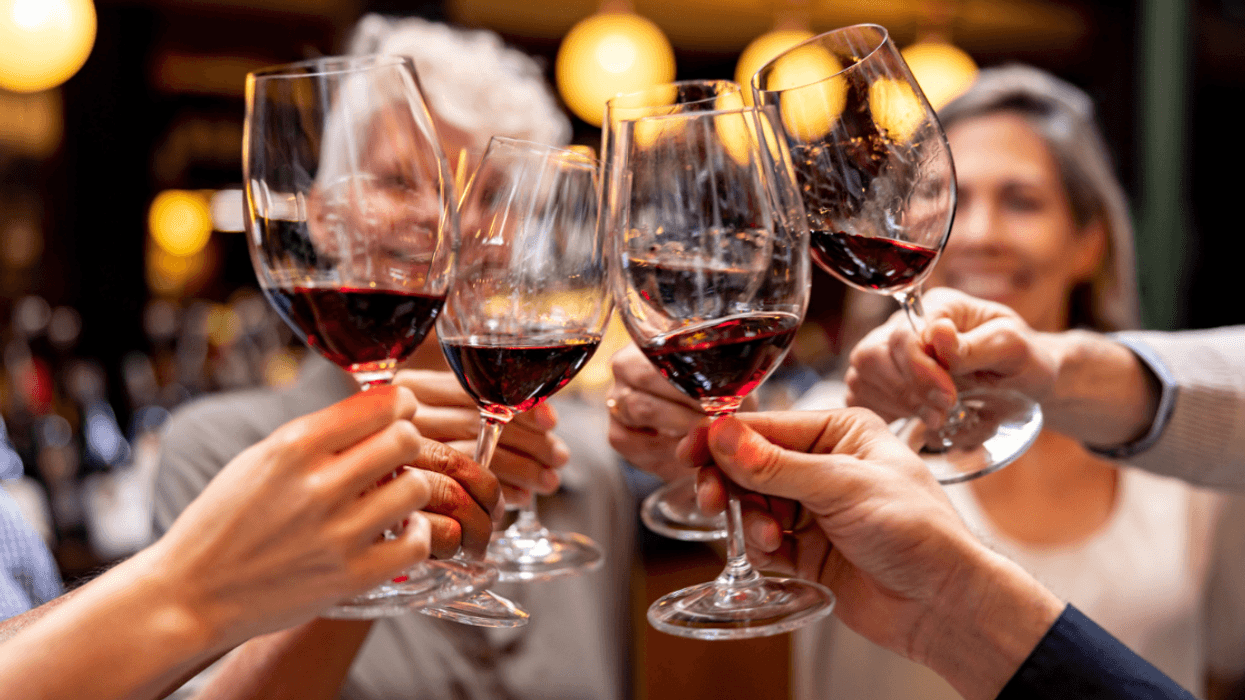 A group of women clinking wine glasses.