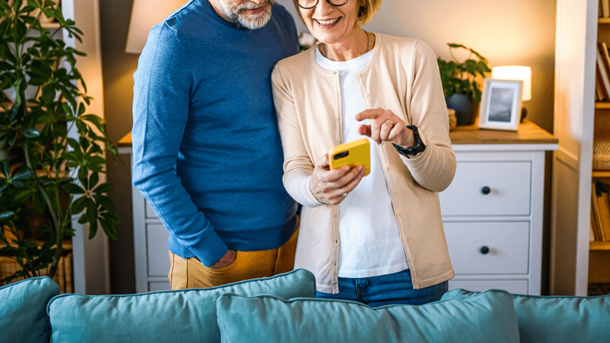 A Man and a woman staring at a cell phone.