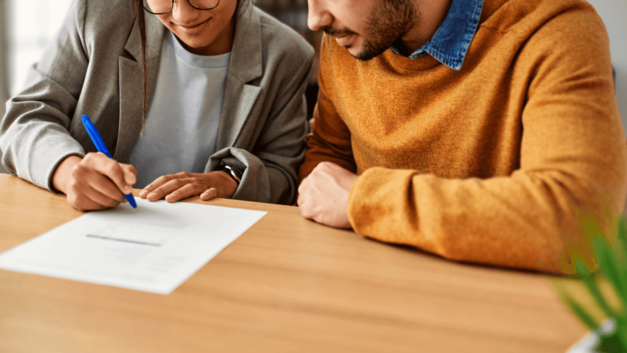 A man and woman signing a piece of paper.