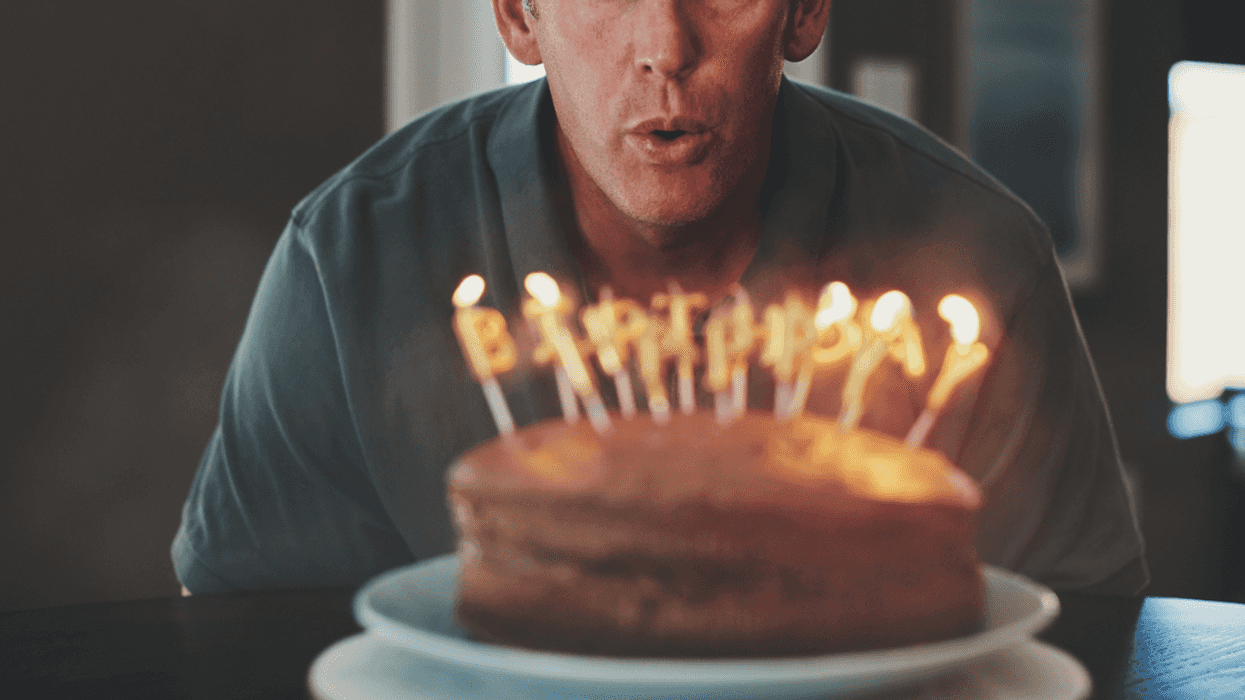 A man blowing out birthday candles.