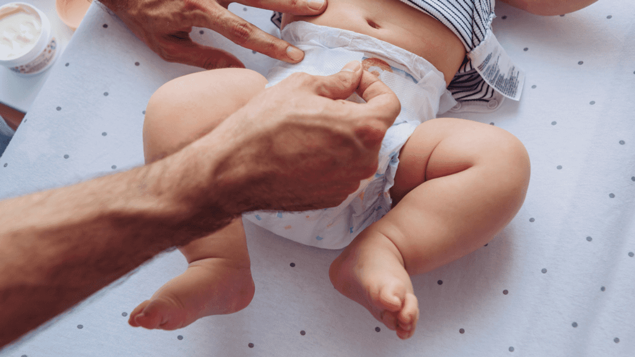 A man changing a baby's diaper.