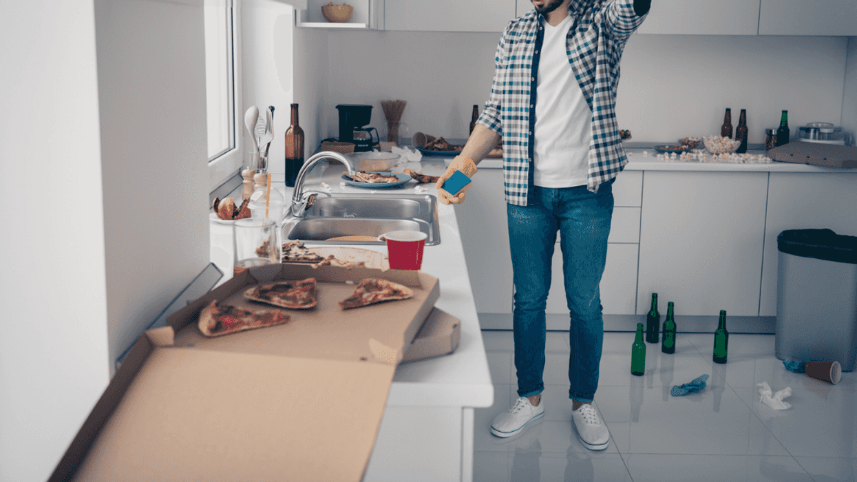A man cleaning up a messy kitchen.