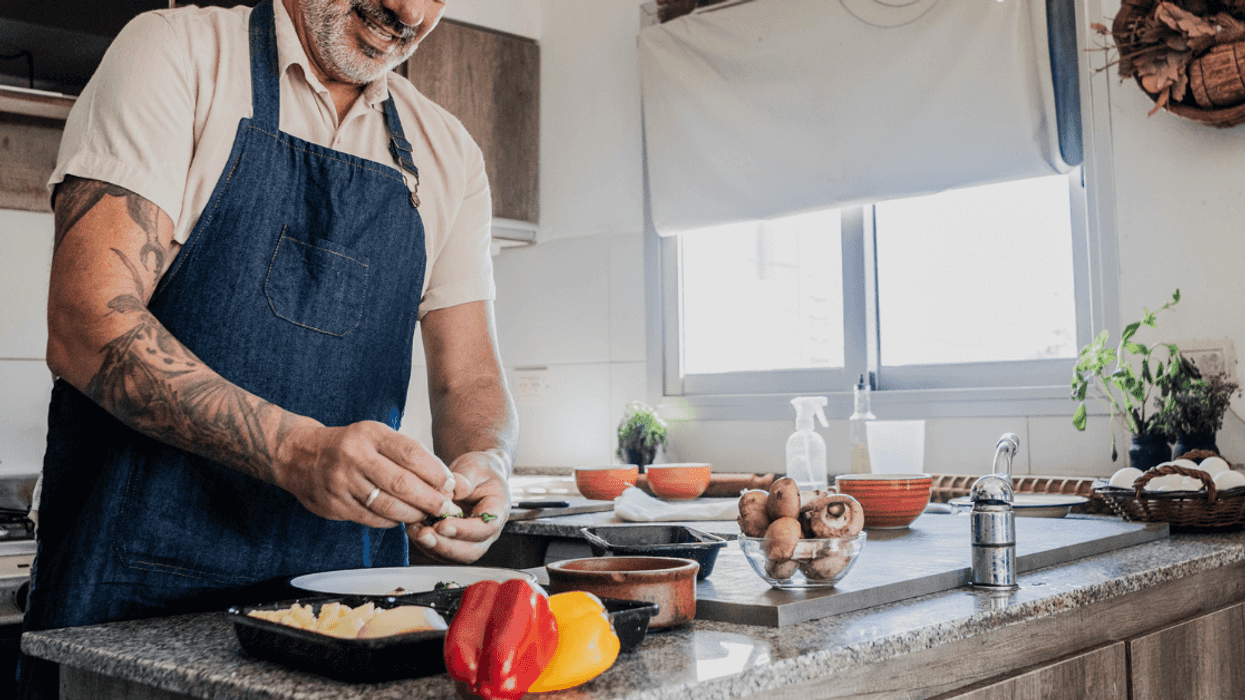 A man cooking in front of a stove.