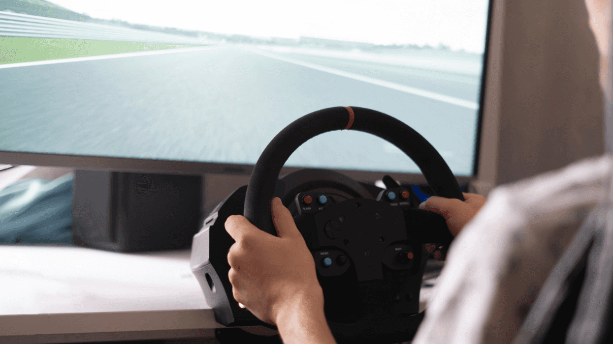 A man driving a racing simulator video game.