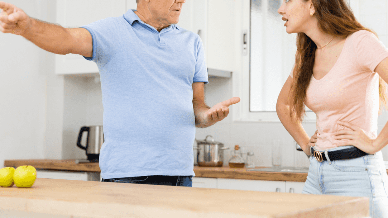 A man emphatically pointing away while talking to a young woman.