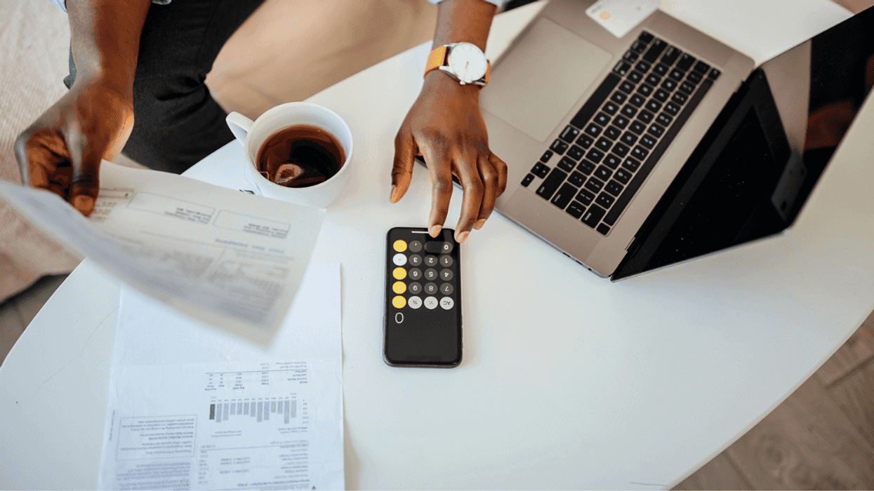 A man going over his finances on a table with a calculator.