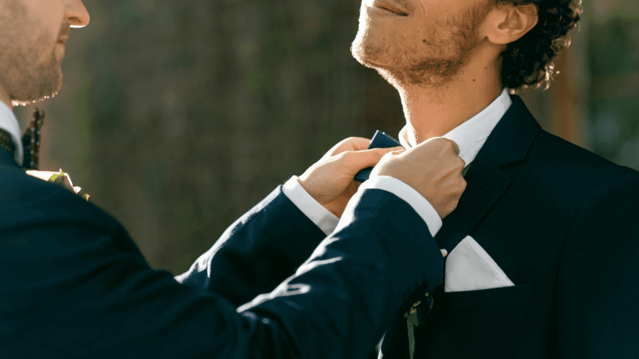 A man helping another man with his bowtie.