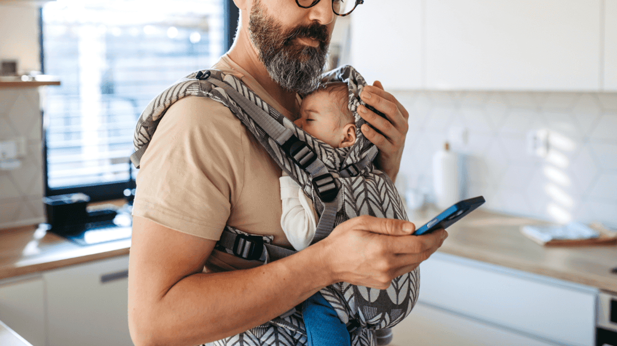 A man holding a baby in a snuggly