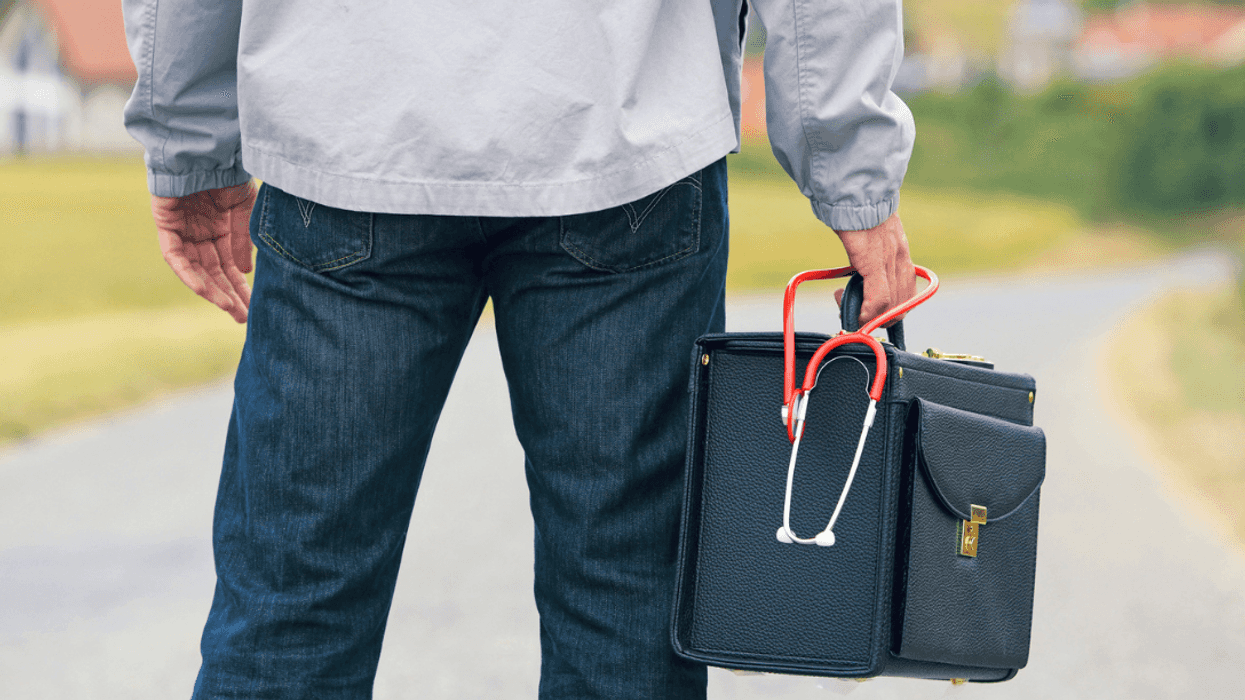 A man holding a bag with a stethoscope lying on top of it.