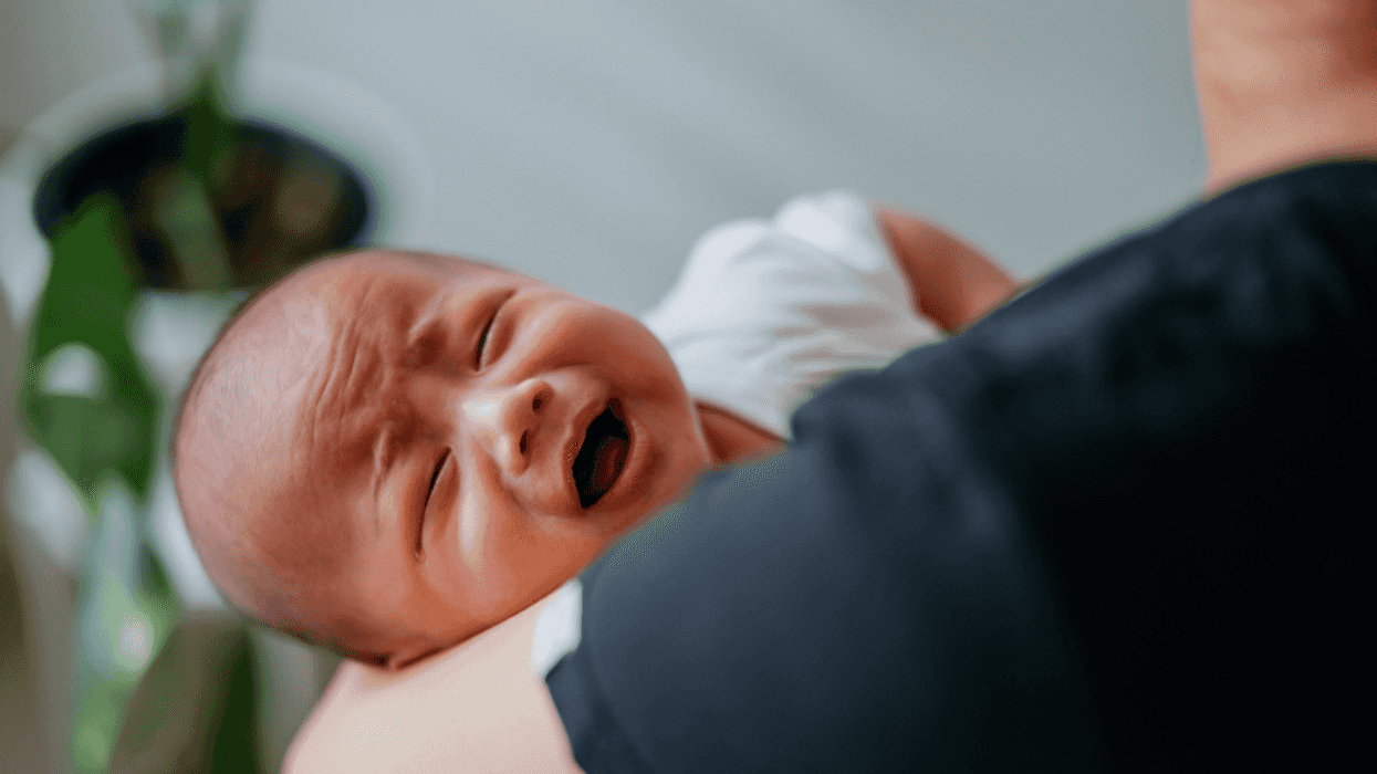 A man holding a crying baby.