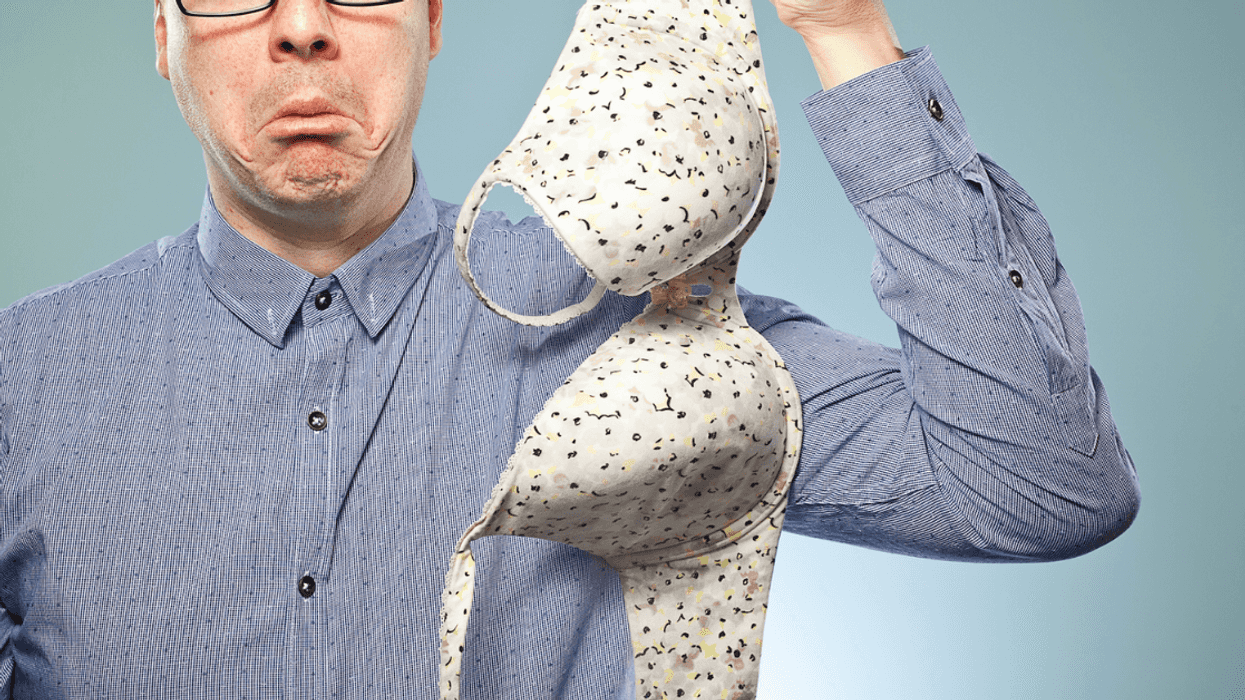 A man holding a polka dotted bra.