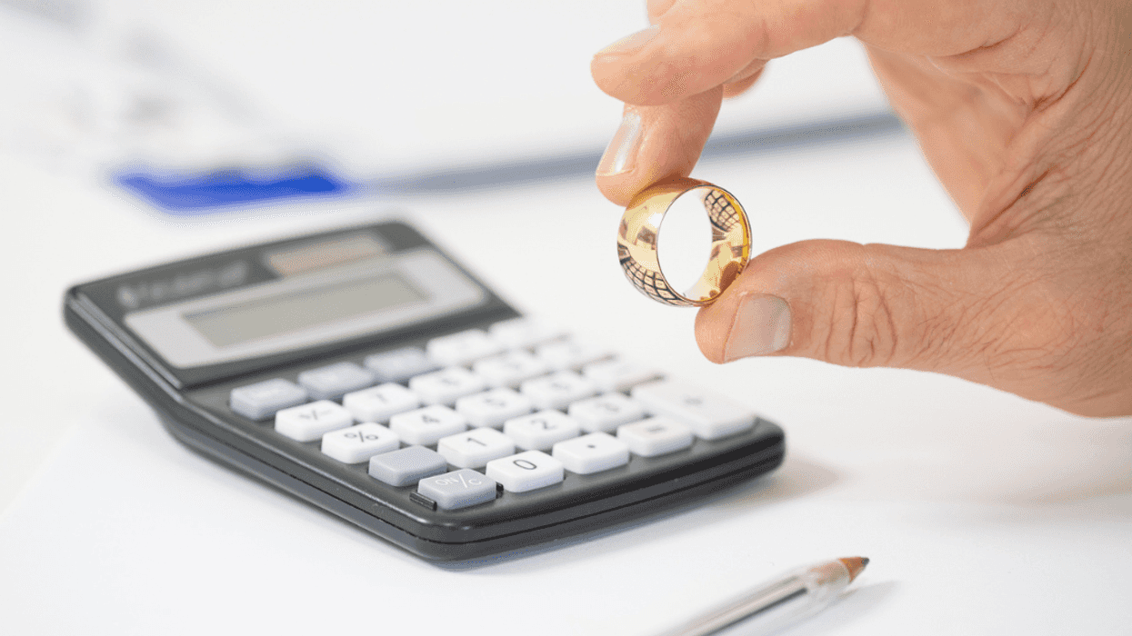A man holding a wedding ring above a calendar.