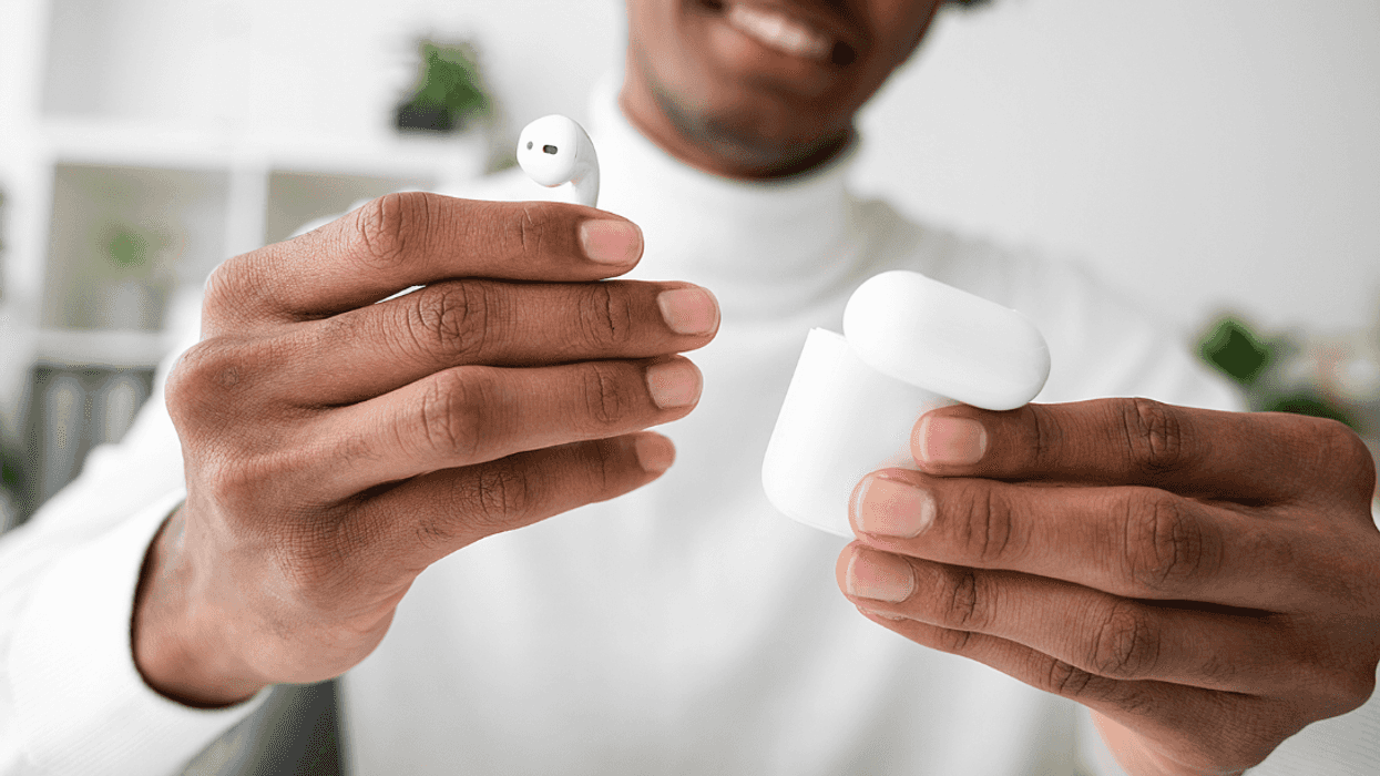 A man holding an Airpod and an Airpod case.