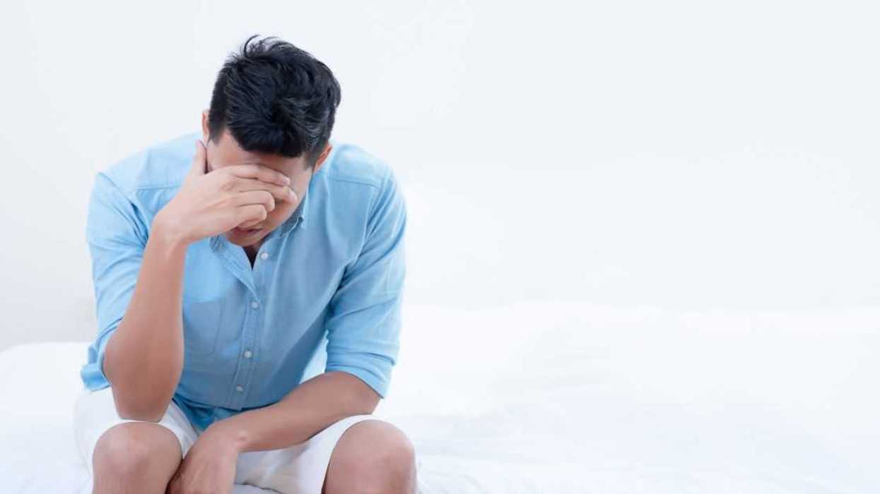 A man holds his head in his hand