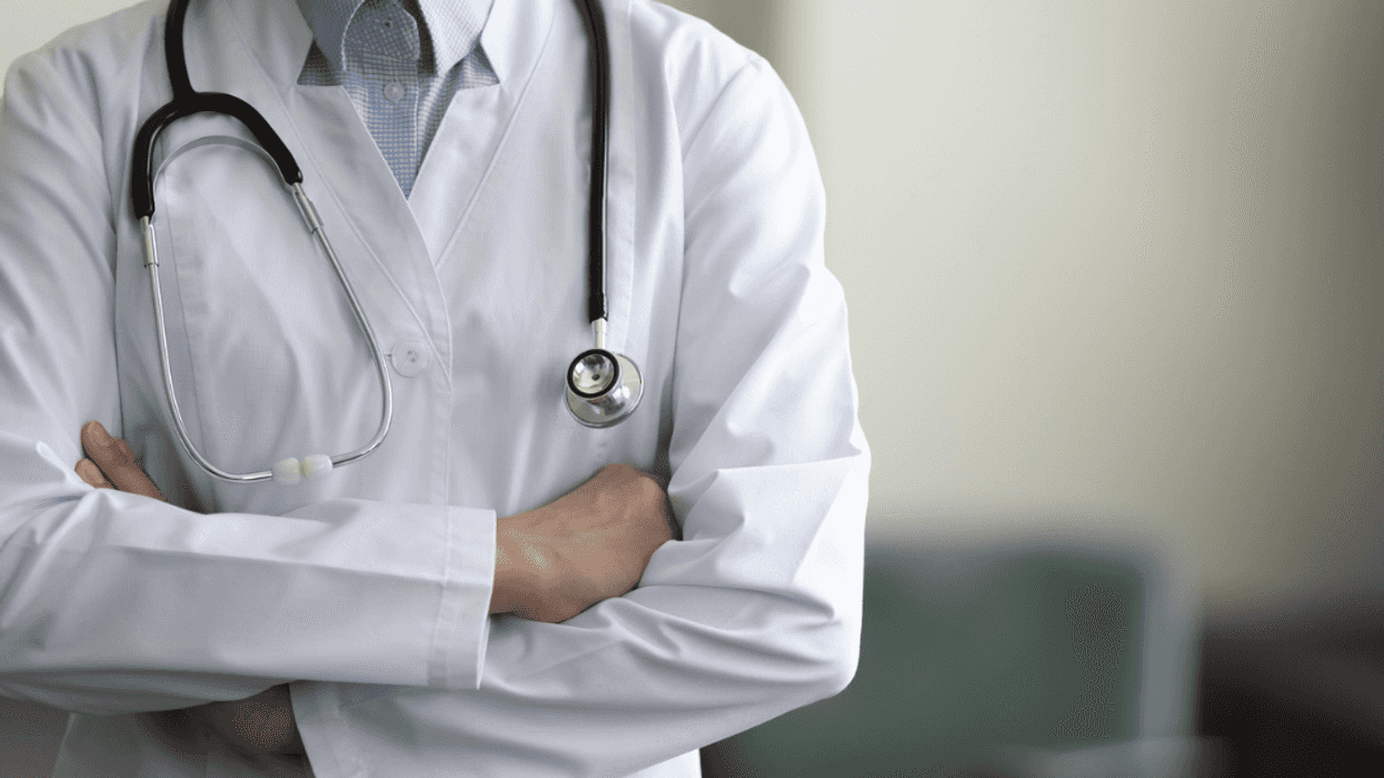A man in a labcoat with a stethescope round his neck.