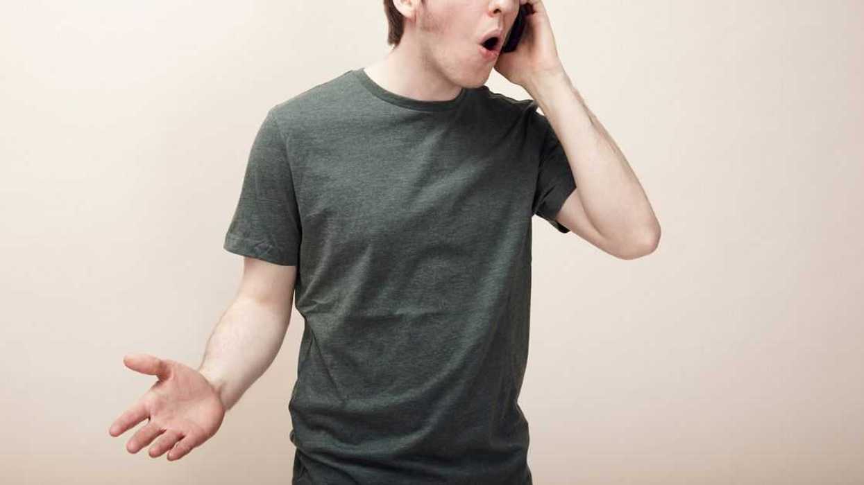 A man is on a phone call that seems to perturb him