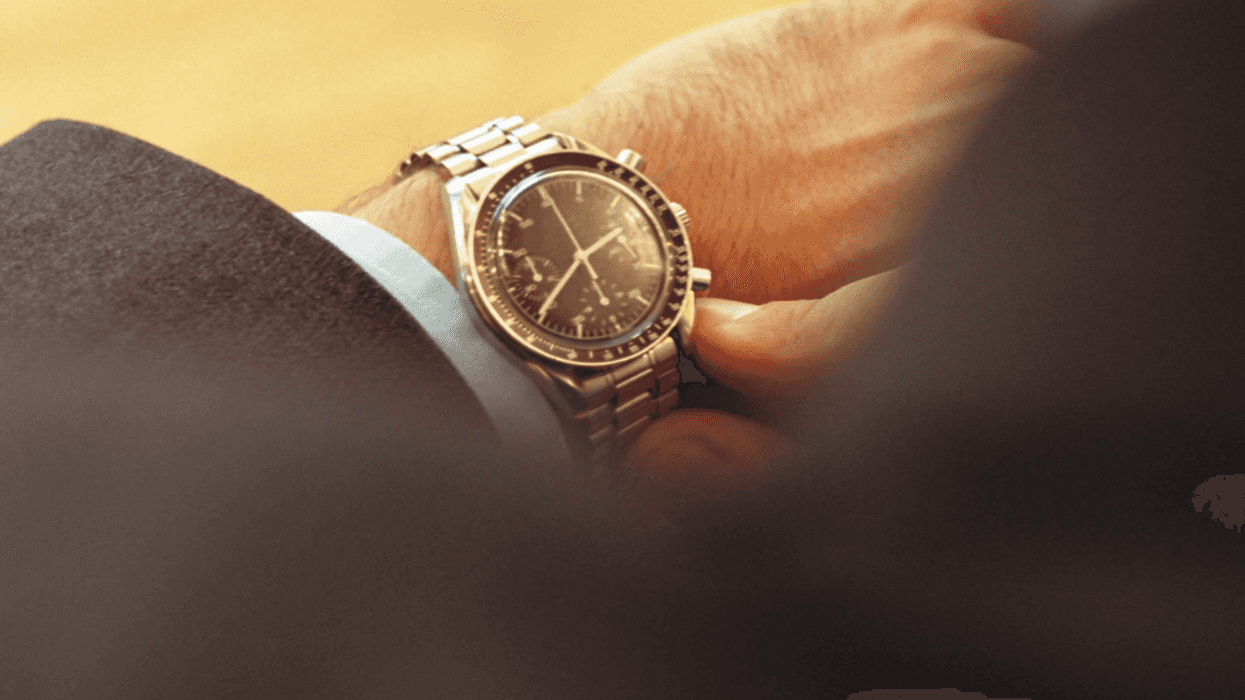 A man looking at a watch on his wrist.