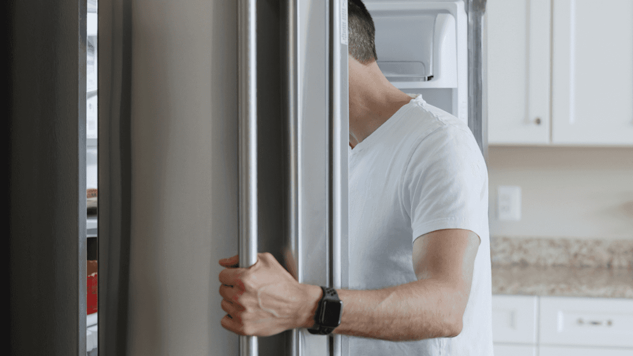 A man looking into a refrigerator.
