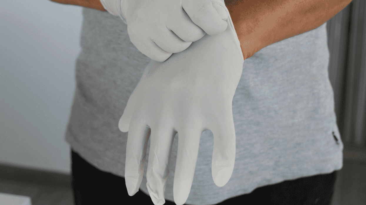 A man putting on latex Gloves