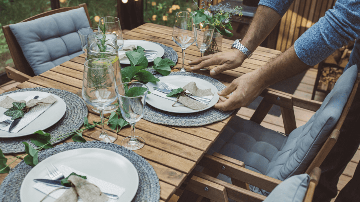 A man setting the dinner table.